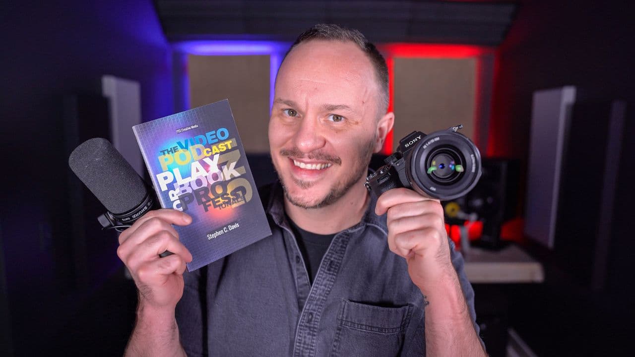 Stephen holding The Video Podcasting Playbook for Professionals and a camera